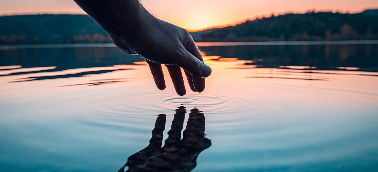 Hand reflection in water - Trauma Therapy